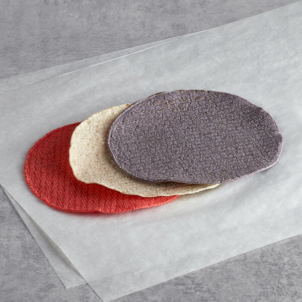 Mission tri-color corn tortillas in yellow, purple, and white on a white surface.