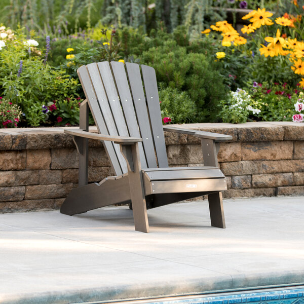 A Lifetime Shale Adirondack chair sitting next to a pool.
