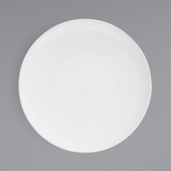 A white porcelain plate with spiral lines on it.