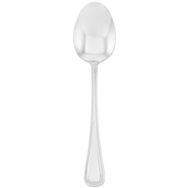 A silver Walco Accolade serving spoon with a white handle on a white background.
