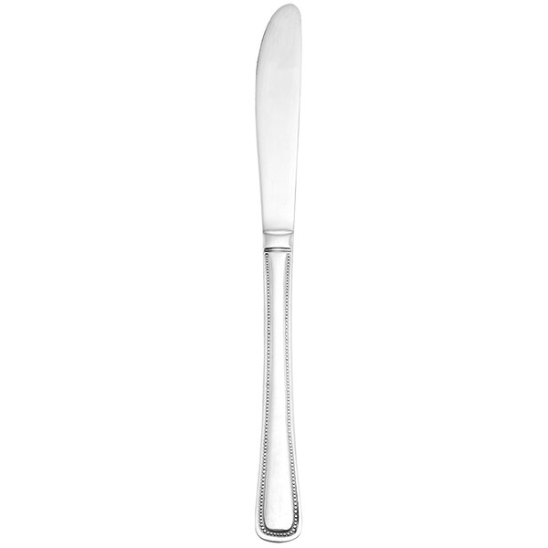 A Walco stainless steel dinner knife with a white handle and silver blade.