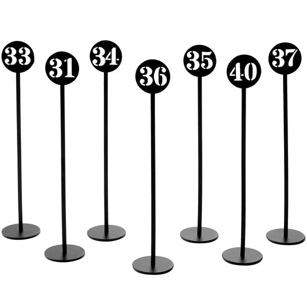 A set of black American Metalcraft table number stands with numbers.