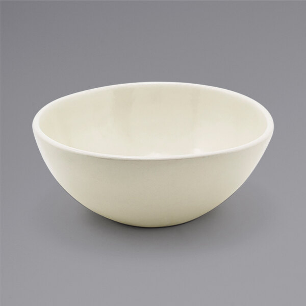 A white Front of the House oval porcelain bowl on a gray surface.