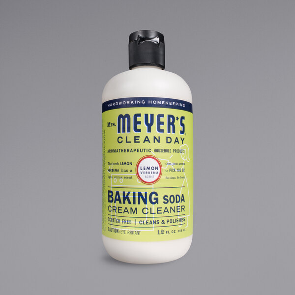 A bottle of Mrs. Meyer's Clean Day Lemon Verbena Baking Soda Cream Cleaner with a close up of the label.