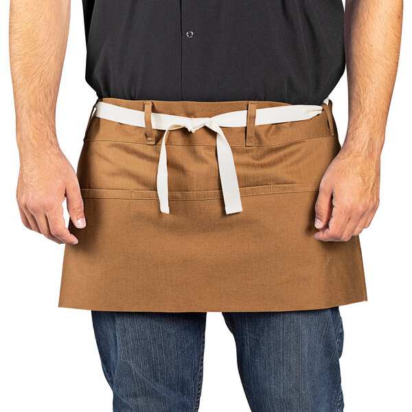 A man wearing a brown Uncommon Chef waist apron with natural webbing.