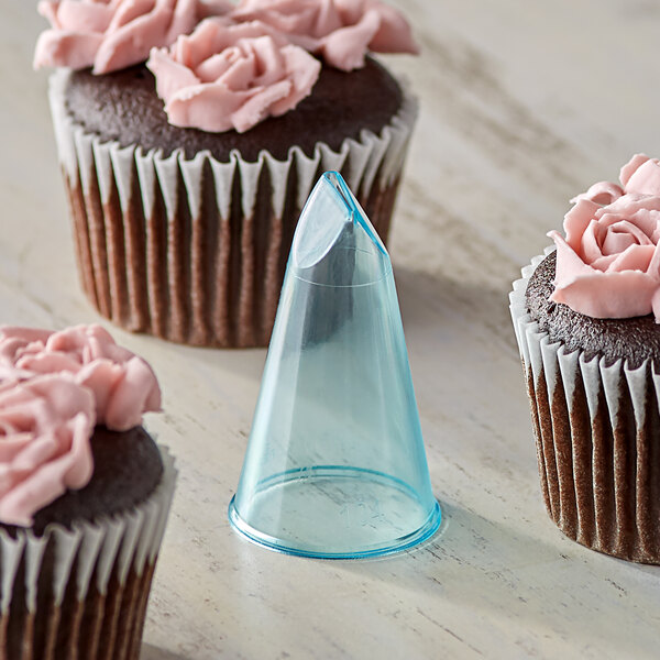 A cupcake with pink frosting piped into a rose shape using an Ateco plastic rose piping tip.