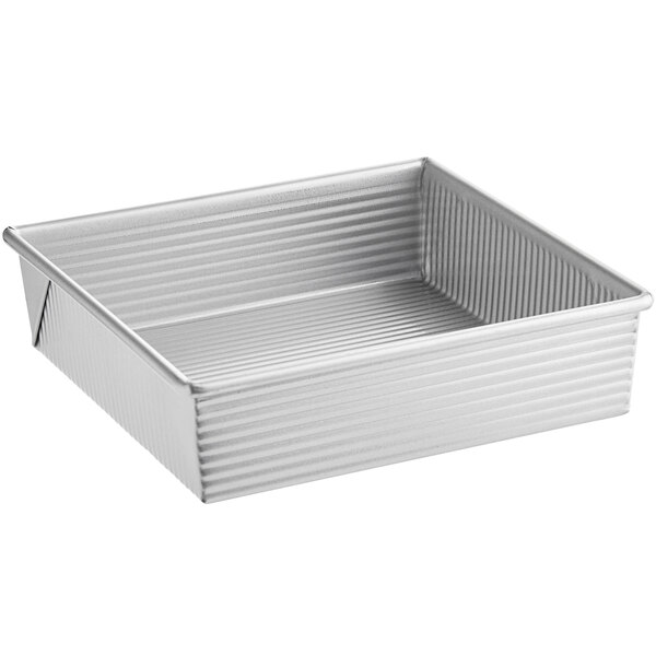 A silver rectangular metal Chicago Metallic square cake pan with a handle.