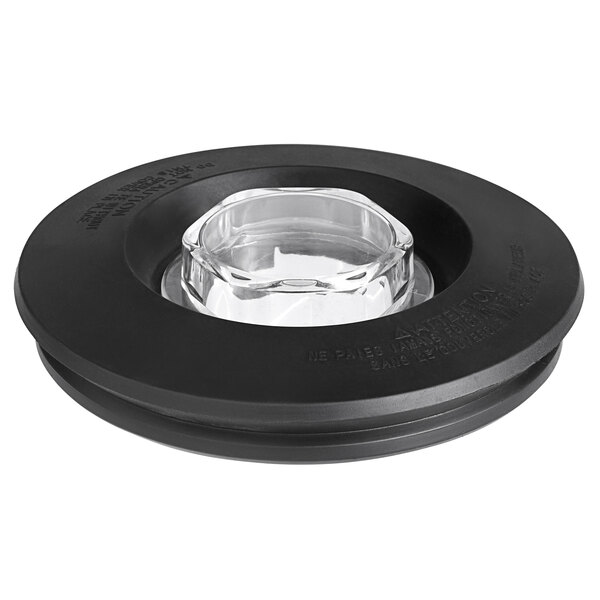 A black plastic jar lid with a clear glass center