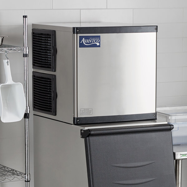 An Avantco air cooled ice machine in a kitchen with a white scoop.