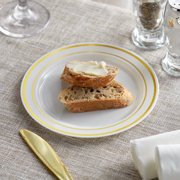 A Visions plastic plate with a piece of bread and a knife on it.