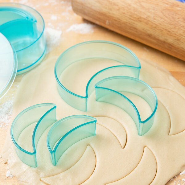 A clear plastic Ateco cookie cutter on dough.