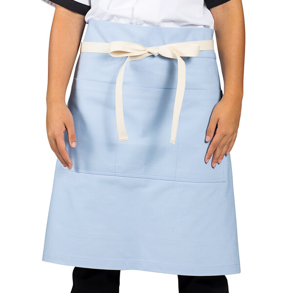 A woman wearing a blue Moxie waist apron with natural webbing.