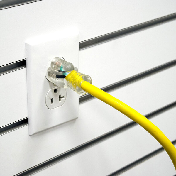 A yellow DuroMax extension cord plugged into a white wall outlet.