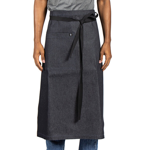 A man wearing a Uncommon Chef denim bistro apron with black webbing.