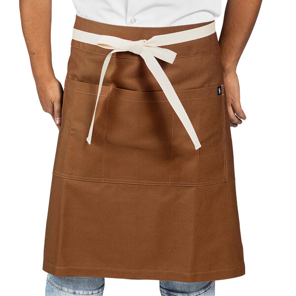 A man wearing a Uncommon Chef brown canvas waist apron with natural webbing.