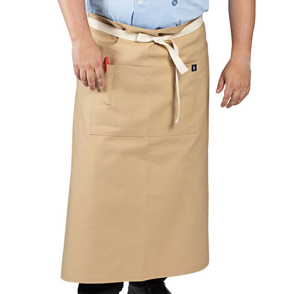 A man wearing a light beige Uncommon Chef Marvel bistro apron.