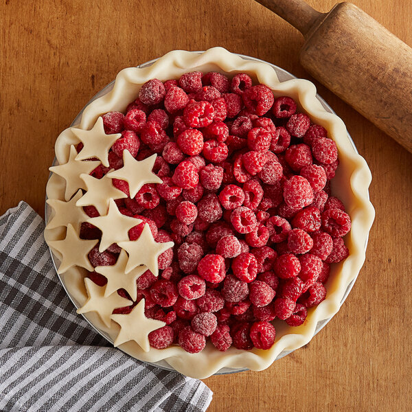 A pie with raspberries and stars on top.