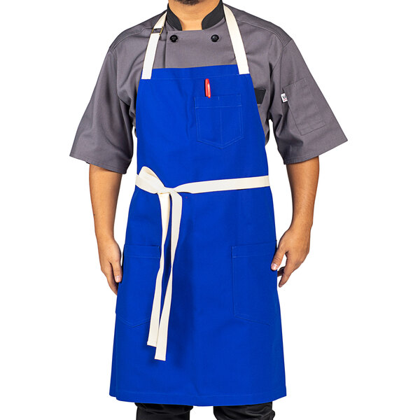 A man wearing a blue Uncommon Chef bib apron with natural webbing.