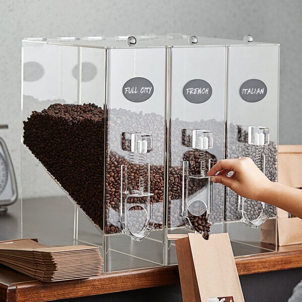 A person putting coffee beans into a Choice coffee dispenser.