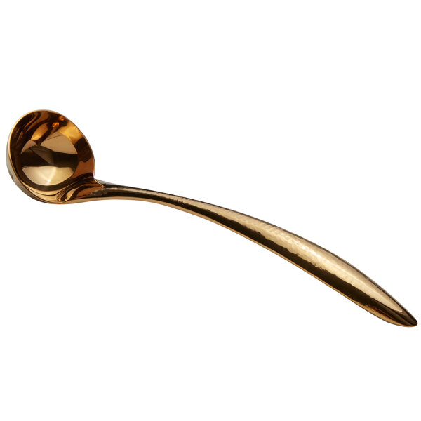 A gold ladle with a long handle.