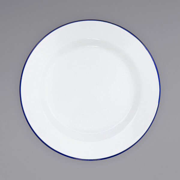A white Crow Canyon Home enamelware plate with a blue rim.