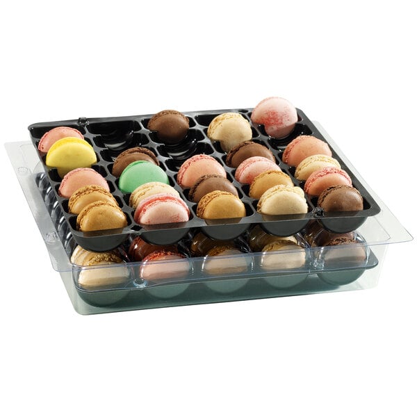 A tray of macarons in a clear plastic container.