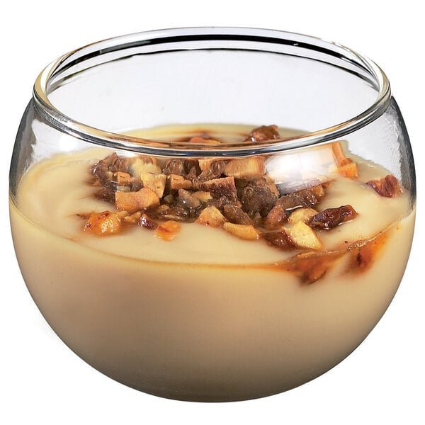 A Solia glass dessert dish filled with pudding and nuts.