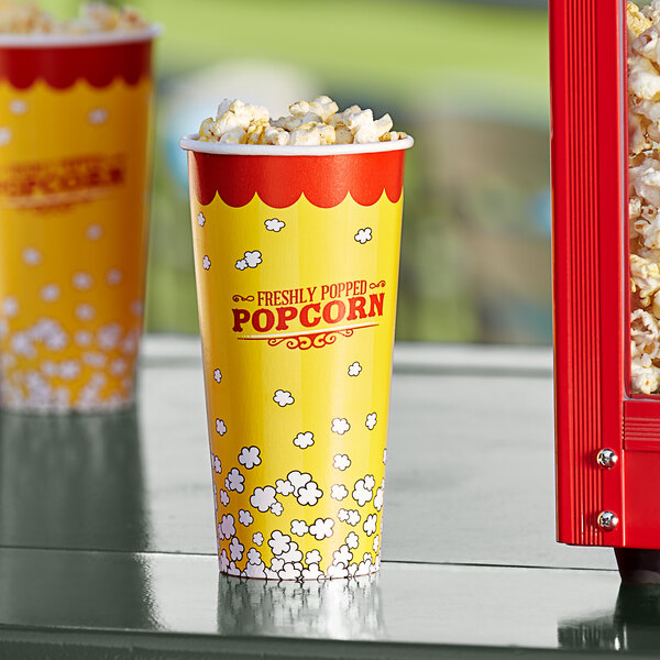 Two yellow and red Carnival King popcorn cups filled with popcorn.