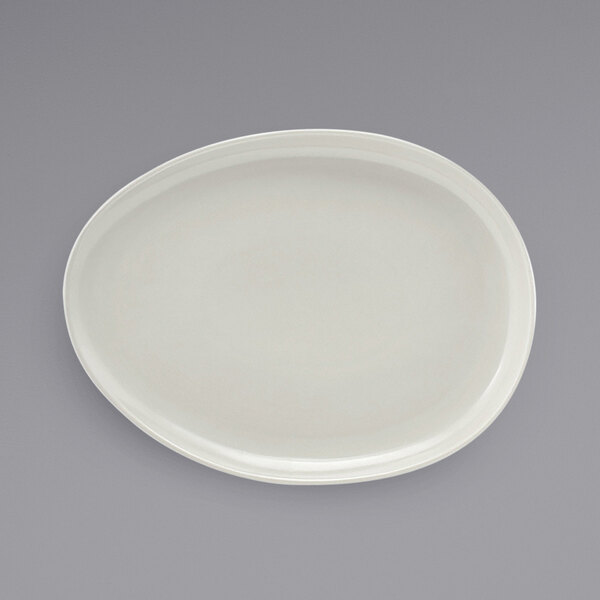 A white porcelain oval plate with a scalloped edge.