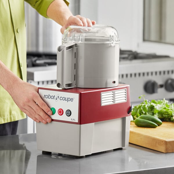 A person using a Robot Coupe food processor to make a salad.