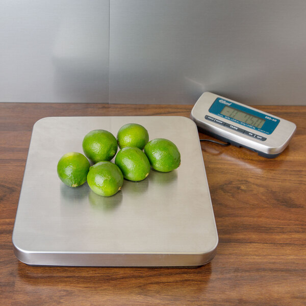 An Edlund digital receiving scale weighing limes on a table.
