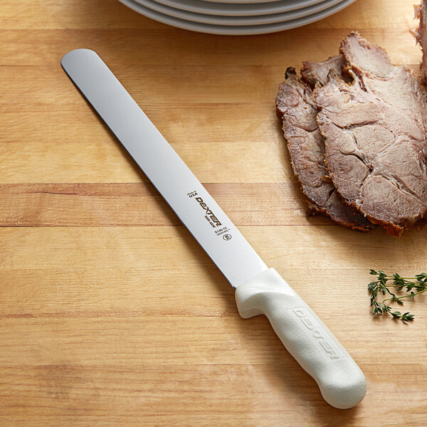 A Dexter-Russell Sani-Safe Slicer knife slicing meat on a cutting board.