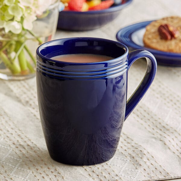A close-up of a blue coffee mug with a drink in it.
