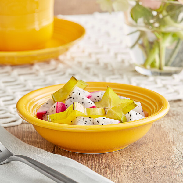 A yellow Acopa Capri stoneware bowl filled with fruit.