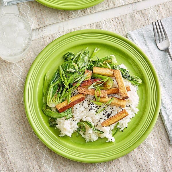 A plate of rice and vegetables on an Acopa Capri green stoneware plate.