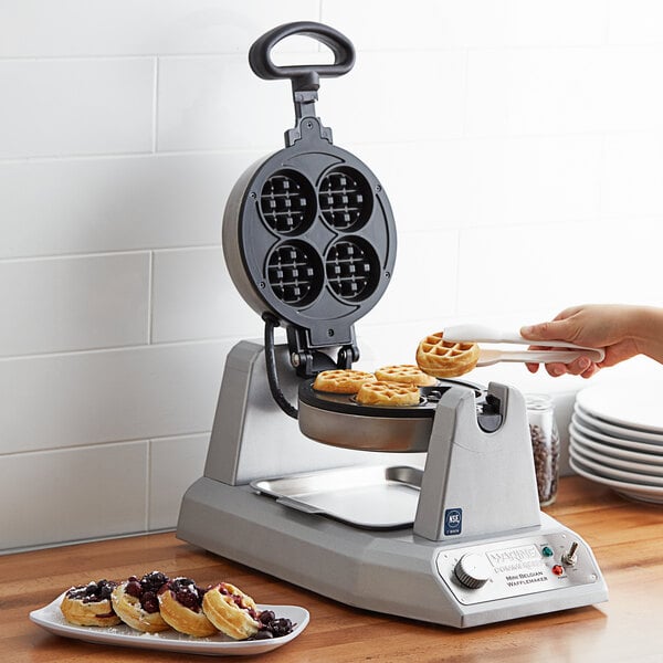 A person using a Waring Mini Belgian Waffle Maker to make waffles.