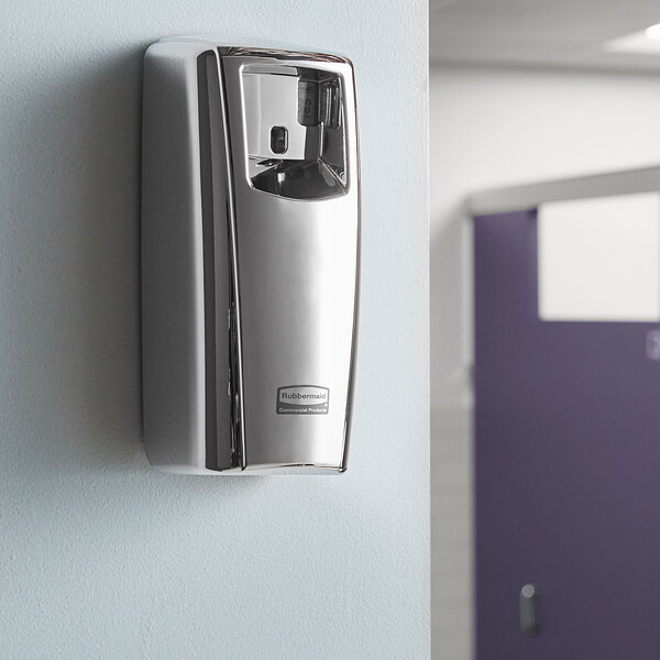 A silver Rubbermaid Microburst 9000 air freshener system on a wall.