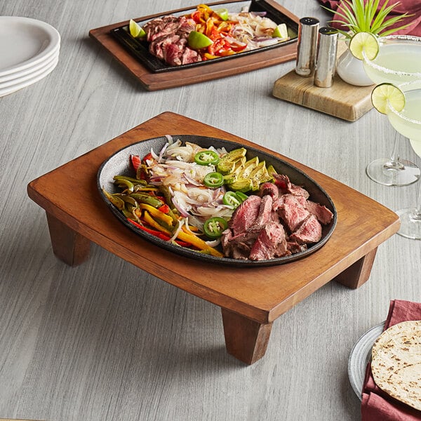 A Valor pre-seasoned cast iron fajita skillet on a table with a tortilla plate.