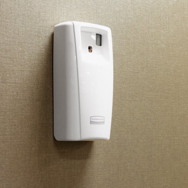 A white Rubbermaid Microburst 9000 aerosol air freshener system mounted on a wall.