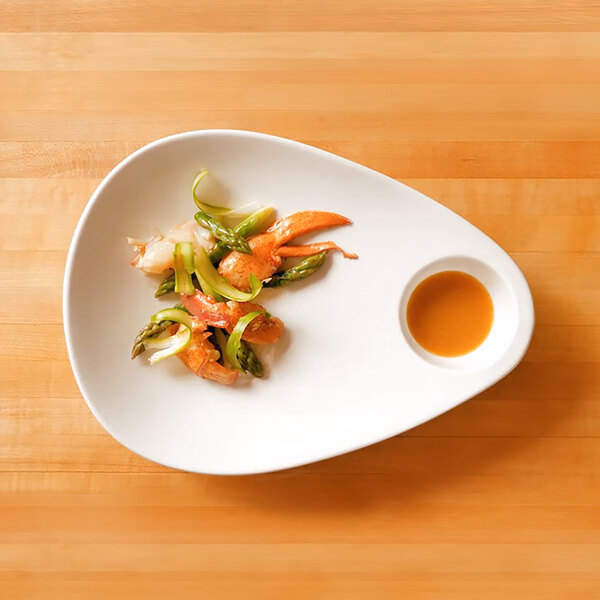 An Ellipse white porcelain sampler plate with food on it.