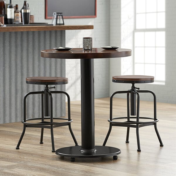A Lancaster Table & Seating cast iron counter height table base with a black metal spider and FLAT Tech equalizer table levelers.