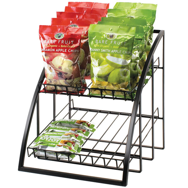 A black Cal-Mil wire merchandiser on a counter with bags of apple chips and fruit.