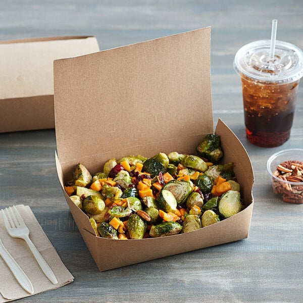 A Fold-Pak Bio-Plus Dine take-out box of food next to a drink and plastic utensils.