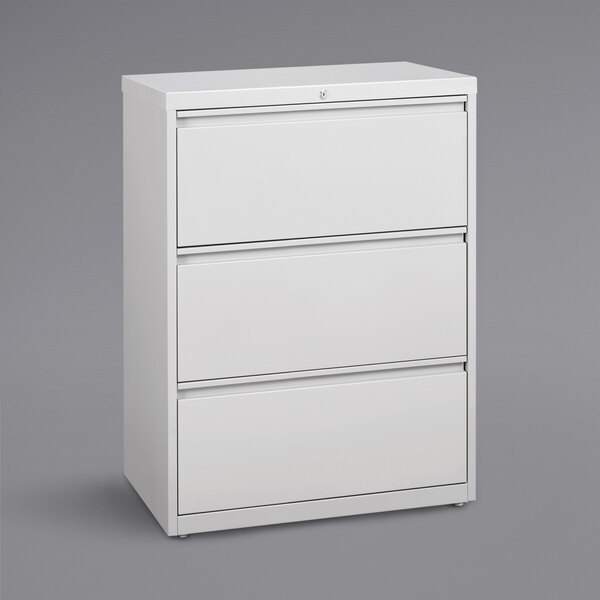 A white Hirsh Industries three-drawer file cabinet.