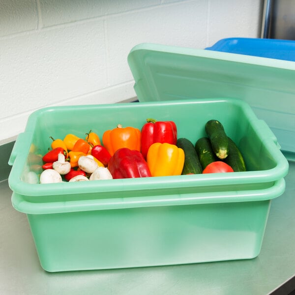A green plastic container with vegetables in it.