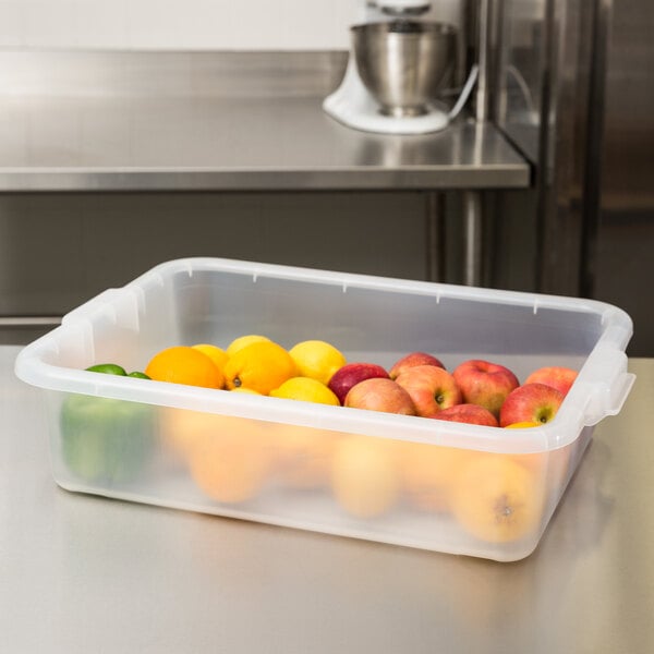 A plastic container full of yellow and red apples.