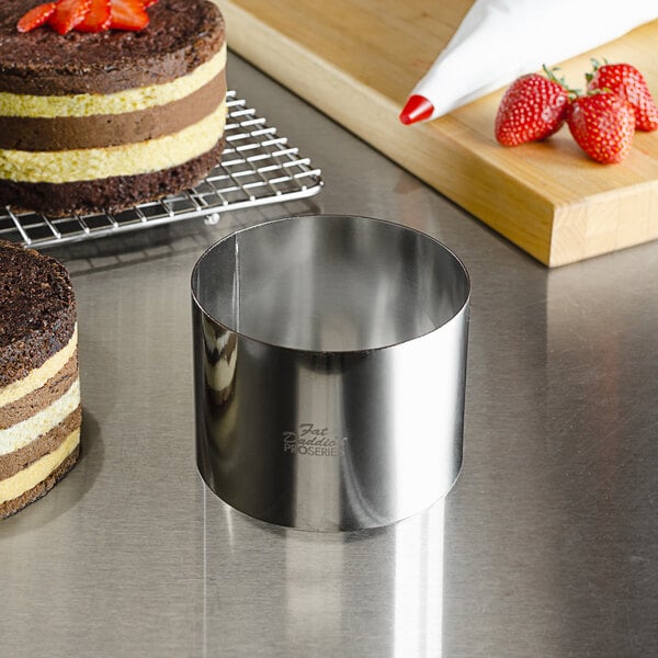 A stainless steel round cake in a Fat Daddio's stainless steel ring mold.