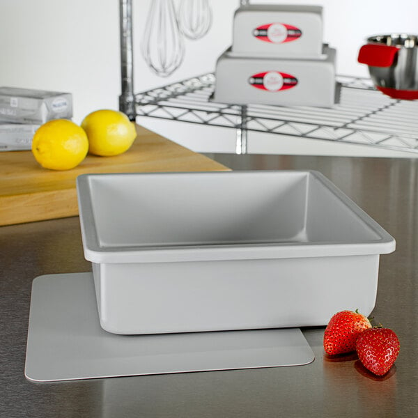 A Fat Daddio's square cheesecake pan with a removable bottom on a kitchen counter.