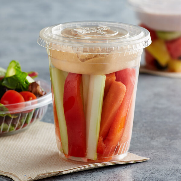 A Fabri-Kal plastic parfait cup with a lid and vegetables inside.