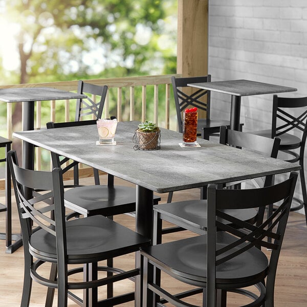 A Lancaster Table & Seating rectangular table with a Textured Toscano finish, chairs, and drinks on it.